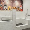 a white bathroom with a mural on the wall